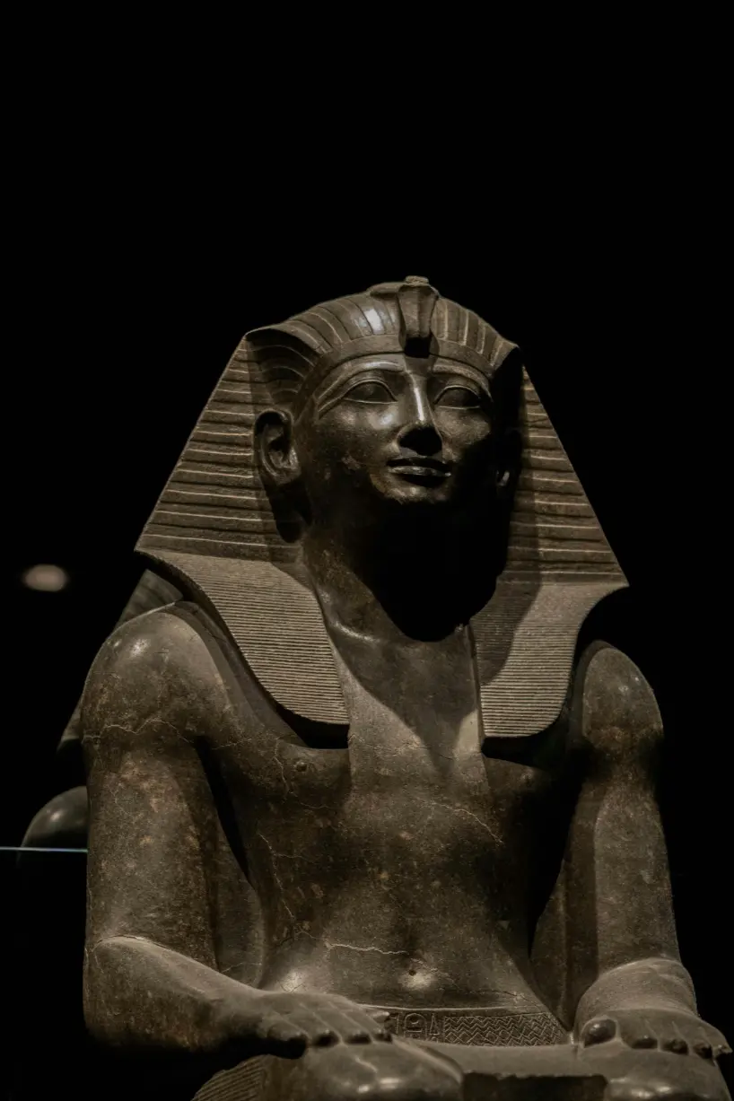 Seated pharaoh statue at the Grand Egyptian Museum in Cairo, showcasing ancient Egyptian royal art and craftsmanship.