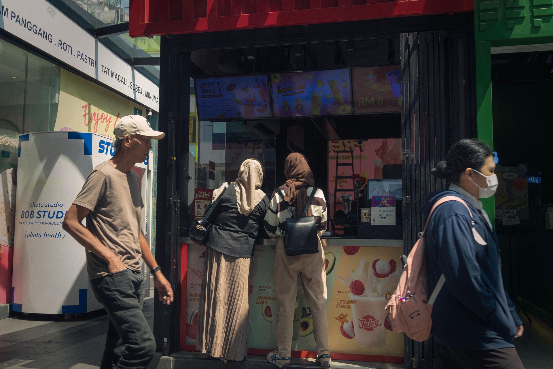 Local residents and visitors walk and shop at open‑air street stalls in Bukit Bintang, Kuala Lumpur, illustrating the city’s multicultural everyday life.