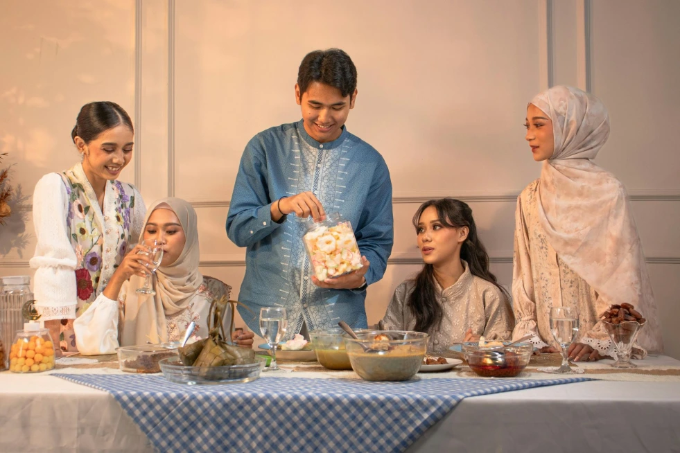 A Muslim family gathered around a table enjoying a traditional Iftar meal together.