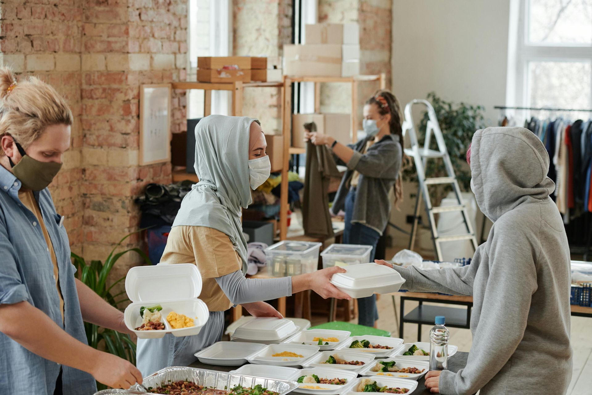 Volunteers serving food to strangers at a community iftar table, illustrating Ramadan’s spirit of charity.